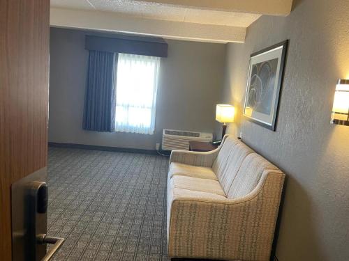a living room with a couch and a window at Hotel O Suites & Conference Centre Urbana-Champaign University in Urbana