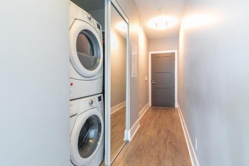 a laundry room with a washer and dryer next to a hallway at 1 Bedroom 26 Floor DT near CN Tower in Toronto