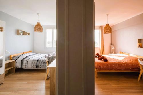 a bedroom with two beds and a table in it at Le Grandmont - 100m du parc - au pied de la faculté des sciences in Tours