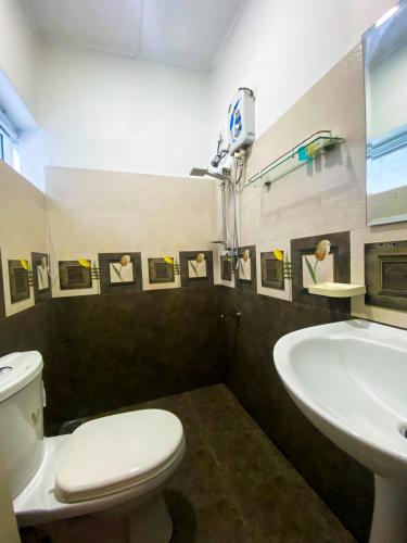 a bathroom with a white toilet and a sink at Sky Garden Kandy in Kandy