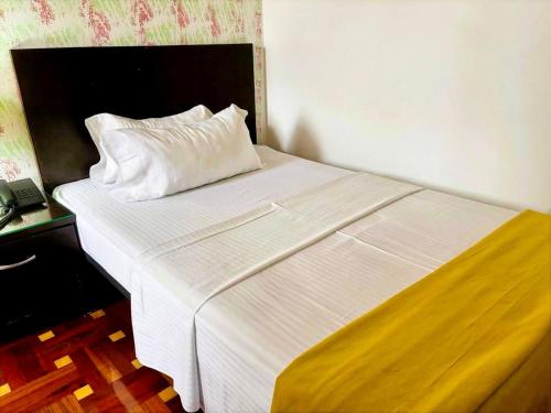 a white bed with a pillow on top of it at Casa Coliving 121 in Bogotá