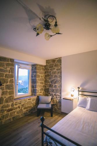 a bedroom with a bed and a chair and a window at Locanda Vecchio Caseificio in Toano