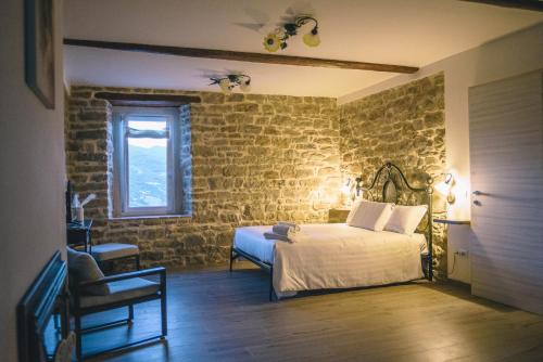 a bedroom with a bed in a brick wall at Locanda Vecchio Caseificio in Toano
