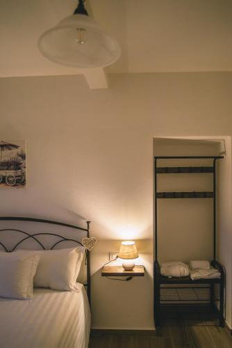 a bedroom with a bed with a lamp and a mirror at Locanda Vecchio Caseificio in Toano