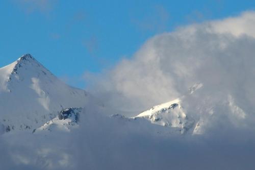 a mountain covered in snow and clouds in the sky at Belcombes in Verbier