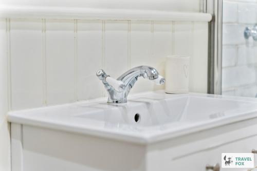 a white sink in a bathroom with a mirror at Seagull Cottage in Hunstanton