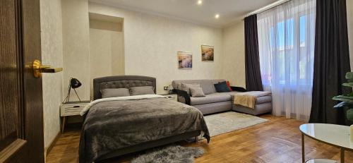 una camera da letto con un letto e un divano di Затишні апартаменти зі сховищем на Святогеоргієвській 15 a Kryvyj Rih