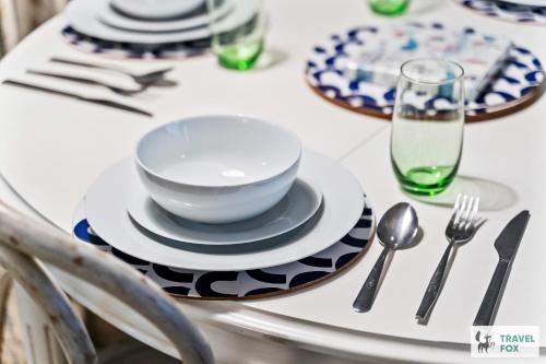 a table with plates and silverware on a table at Seagull Cottage in Hunstanton