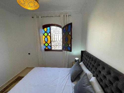 a bedroom with a bed and stained glass windows at Diaft'na in Marrakech