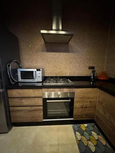 a kitchen with a stove and a microwave at Diaft'na in Marrakech