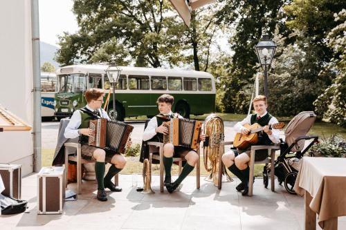a group of boys playing accordion in front of a bus at Hotel Brücklwirt in Niklasdorf