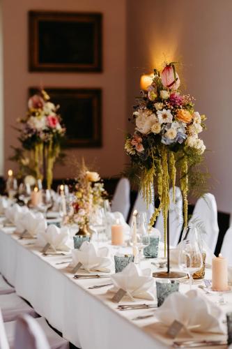 a long white table with flowers on it at Hotel Brücklwirt in Niklasdorf