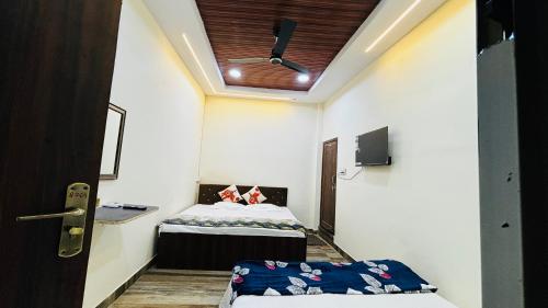 a small room with a bed and a ceiling at Shree nidhi comfort stay MAHAKAL ki krupa ujjain in Ujjain