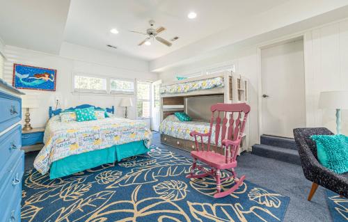 a bedroom with two beds and a chair at Gypsea Rose in Southern Shores