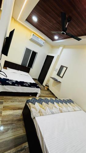 two beds in a room with a ceiling at Shree nidhi comfort stay MAHAKAL ki krupa ujjain in Ujjain