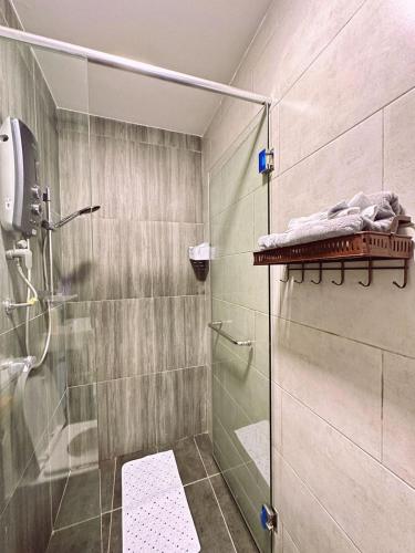 une salle de bain avec une douche avec une porte vitrée dans l'établissement KL 7-9 Pax Lux&Premium Near Farm In The City, à Gua Sai