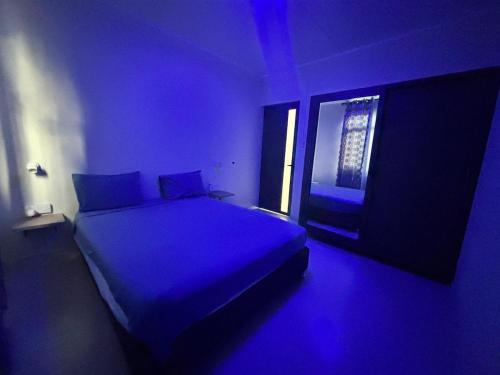 a blue room with a bed with a window at Seaview escape - modern & cozy in Baie du Cap