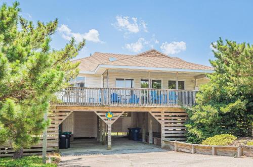 a large house with a porch with a deck at High Tides - D3850 in Duck