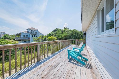 a green bench sitting on a deck on a house at High Tides - D3850 in Duck