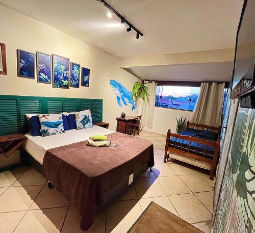 a bedroom with a large bed and a window at Chamos Hostel Cultural in Arraial do Cabo