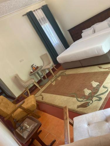 a view of a bedroom with a bed and a chair at Buladde Palm Villa Hotel in Kampala