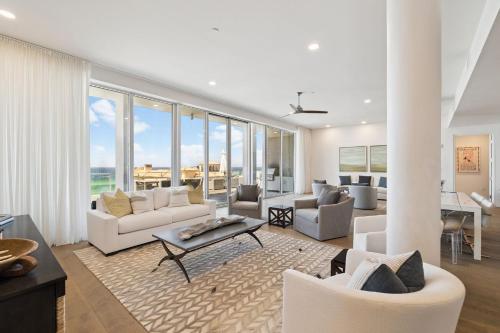 Una sala de estar con muebles blancos y grandes ventanales. en Luxurious Penthouse Condo with Stunning Gulf Views! #402 Viridian in Seagrove 5BR Sleeps 12 condo, en Santa Rosa Beach