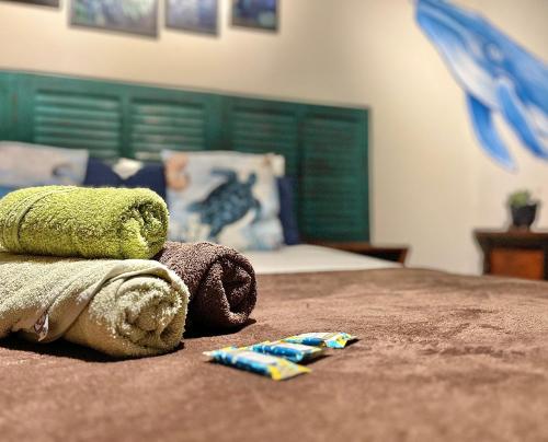 a bedroom with a bed with a green head board at Chamos Hostel Cultural in Arraial do Cabo