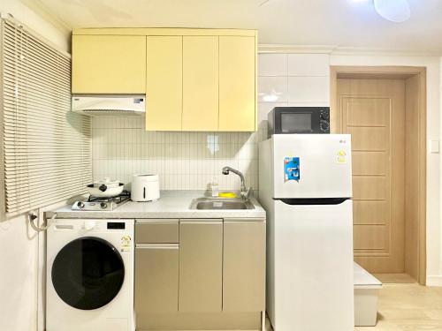 a kitchen with a white refrigerator and a dishwasher at Konkuk Univ 2BR Cozy Apartment near Subway in Seoul