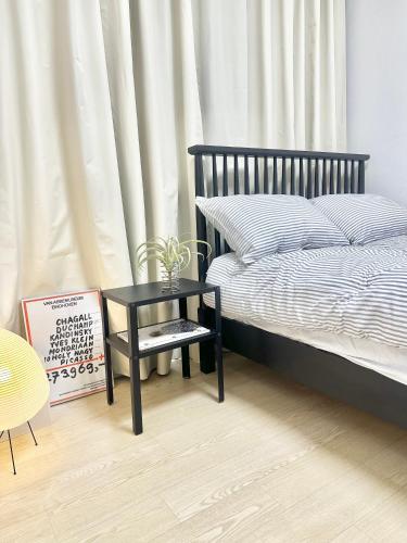 a bedroom with a bed and a side table at Konkuk Univ 2BR Cozy Apartment near Subway in Seoul