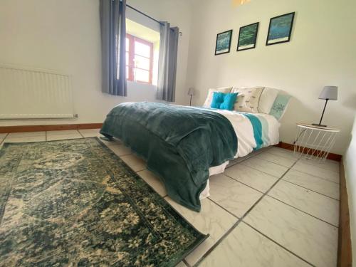 a bedroom with a large bed and a rug at La Detourbe apartment in Beauvain