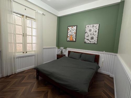 a bedroom with green walls and a bed in it at Hoshi Dalat Fullhouse in Xuan An