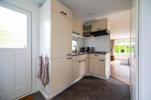 a kitchen with white cabinets and a large window at De Eik in Putten