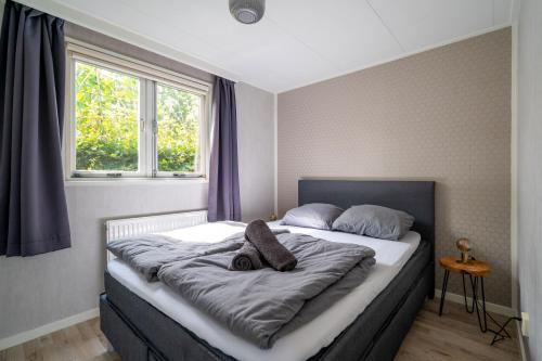 a bedroom with a large bed with a window at De Eik in Putten