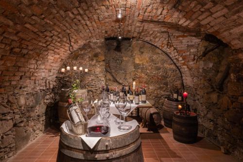 a wine cellar with a table with wine bottles and glasses at Hotel Brücklwirt in Niklasdorf