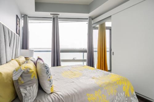a bedroom with a bed with yellow and gray pillows at Sunshiny 1 BD 61st Floor Outstanding View in Toronto
