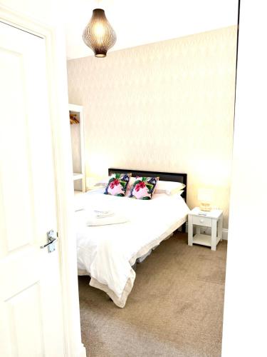 a bedroom with a white bed with pillows on it at Bellaview Apartment Barmouth in Barmouth