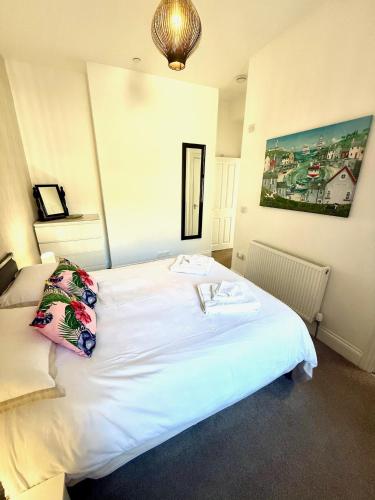 a bedroom with a large white bed with a picture on the wall at Bellaview Apartment Barmouth in Barmouth