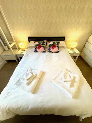 a white bed with two towels on top of it at Bellaview Apartment Barmouth in Barmouth