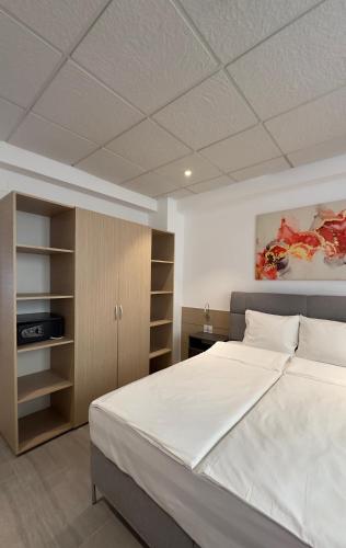 a bedroom with a large white bed and shelves at Heights Accommodation Old Center in Bucharest