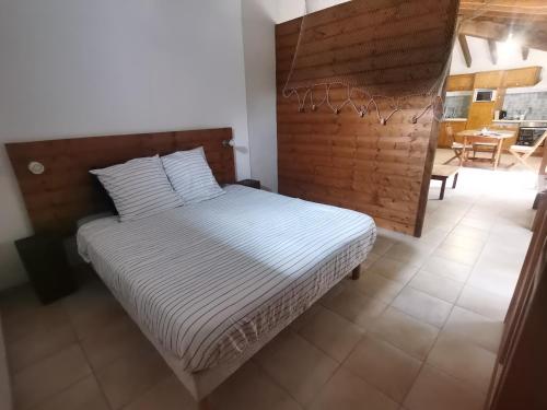 a bedroom with a bed with a wooden headboard at Gîtes Le Chemin du Romarin in Meursac