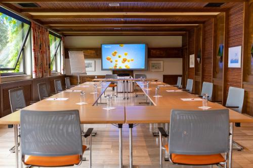 a large conference room with a large table and a screen at Hotel Brücklwirt in Niklasdorf