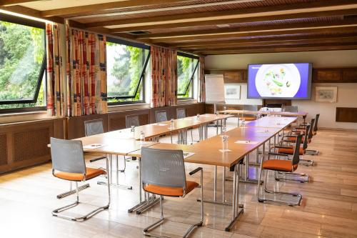 a conference room with tables and chairs and a tv at Hotel Brücklwirt in Niklasdorf