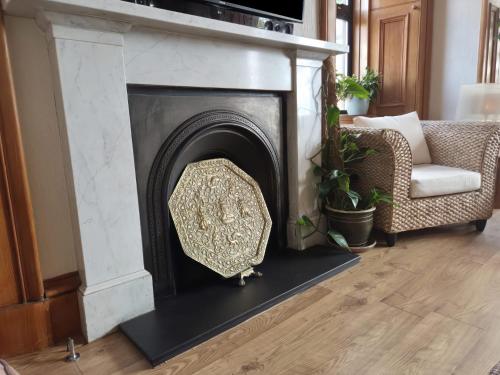 a fireplace in a living room with a couch and a chair at The Old Rectory in Largs