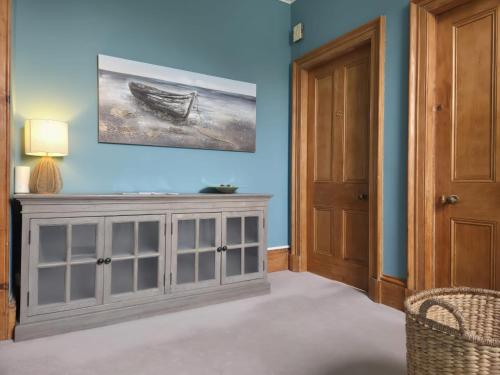 a room with a gray cabinet and a painting on the wall at The Old Rectory in Largs