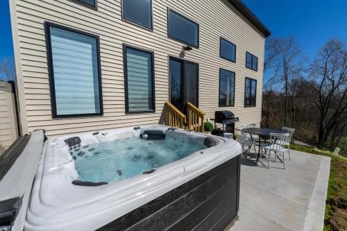 a hot tub on a patio in front of a house at Lakeside Landing - Near Ark - with Hot Tub in Dry Ridge