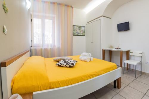 ein Schlafzimmer mit einem gelben Bett mit einer gelben Decke in der Unterkunft B&B Belvedere in Agropoli
