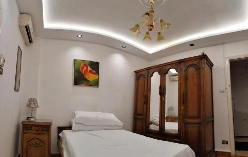 a bedroom with two beds and a ceiling at Dokki private home and GYM in Cairo