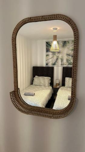 a mirror hanging on a wall with two beds at Bright & Stylish 2 bed Flat, Great Location in Southampton