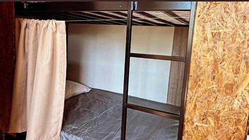 a bunk bed with a ladder in a room at STOP Mar Suite Privada - NI in Nova Iguaçu