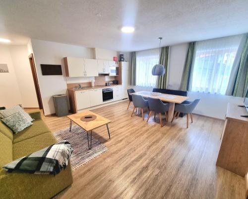a living room with a couch and a table and chairs at valbel in Sankt Anton am Arlberg